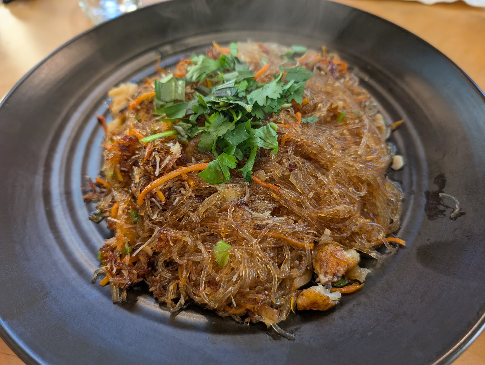 A glass noodle dish garnished with fresh coriander