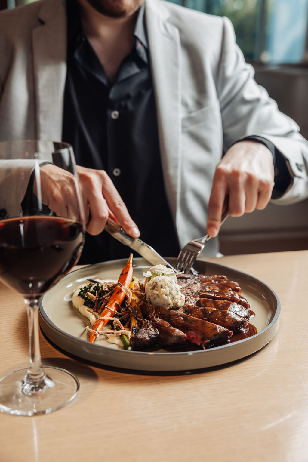 A guest enjoying a steak dish at OVA